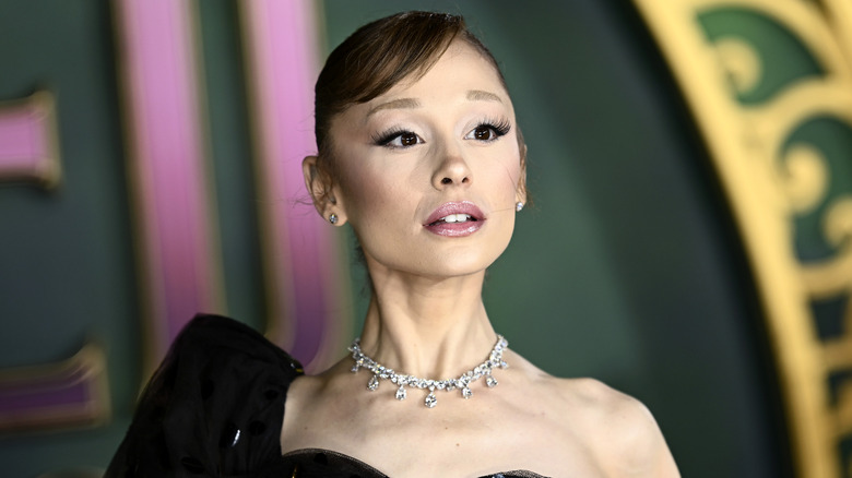 Ariana Grande posing for photos in a black gown