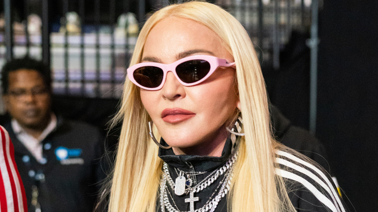 Image of Madonna with sunglasses and a small smile at an event