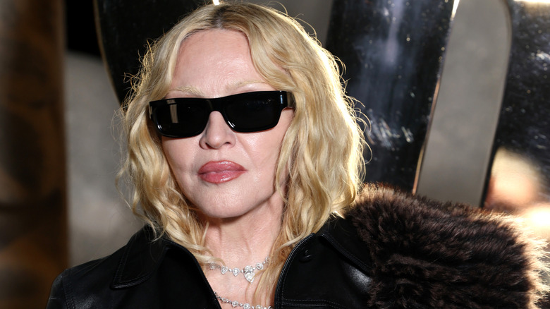 image of Madonna with sunglasses walking outdoors at night