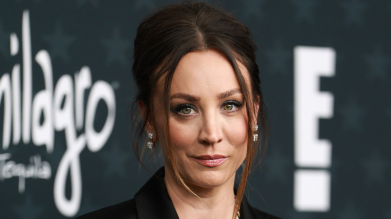 image of Kaley Cuoco with an enigmatic smile and looking at the camera on the red carpet of an event