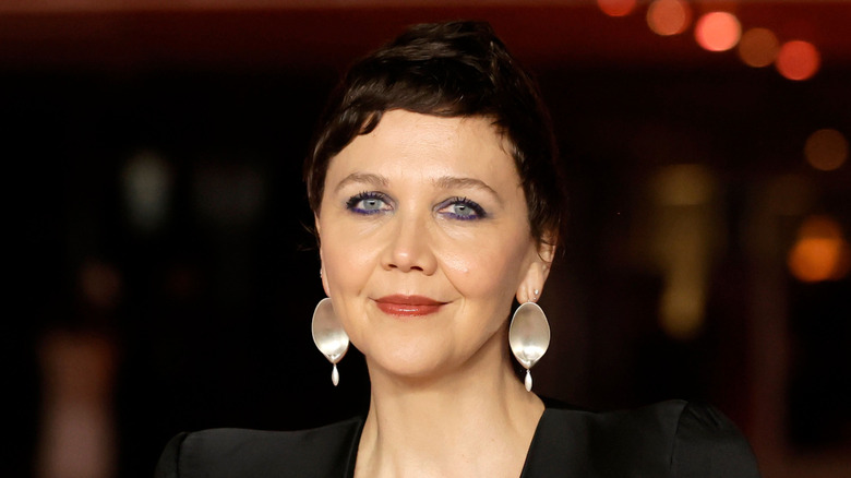 Maggie Gyllenhaal shows off her pixie cut with purple eyeliner and abstract silver earrings