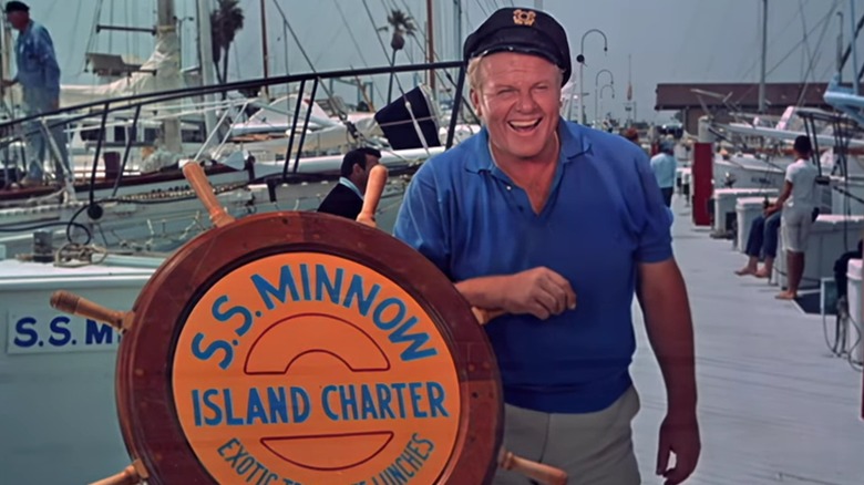 Alan Hale Jr. as The Skipper next to the S.S. Minnow wheel in the Gilligan's Island opening credits