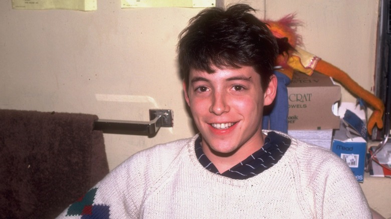 Young Matthew Broderick with messy hair and white sweater