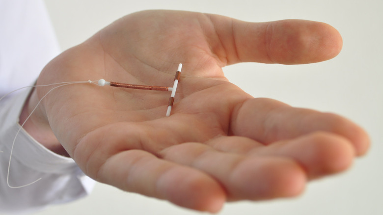 Hand holding a small IUD