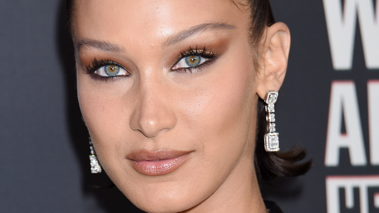 Bella Hadid on red carpet with brown smoky eye and diamond earrings