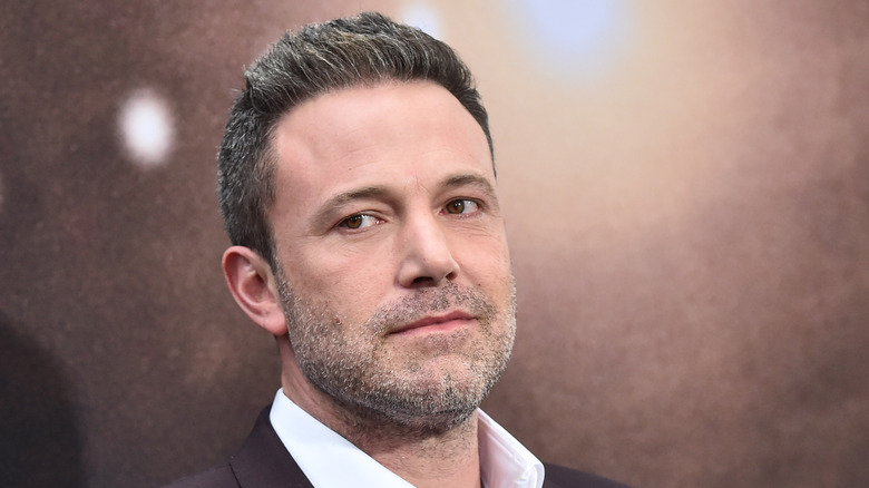 Ben Affleck smirking in a blazer and white collared shirt at the premiere of 'The Way Down.'