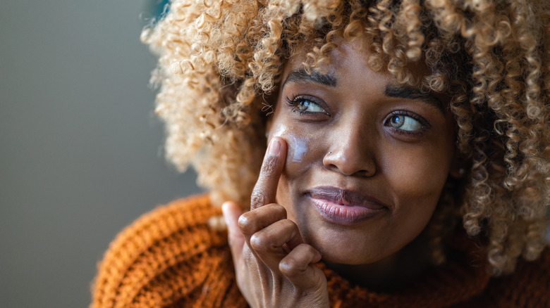Woman moisturizing her skin