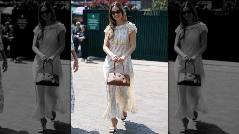Lily James smiling as she walks into Wimbledon in a polka dot dress.