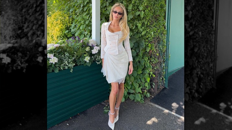 Alix Earle smizing in a white lace dress at Wimbledon 2026.