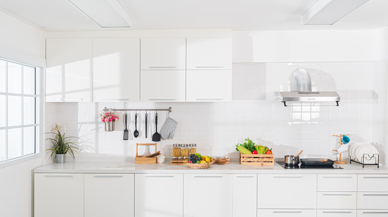 A white, modern kitchen with lots of natural light.