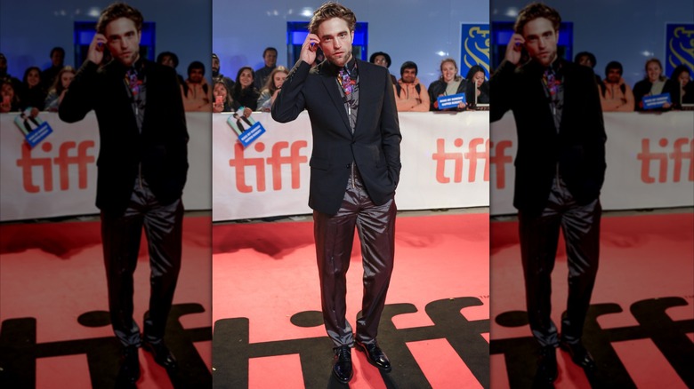 Robert Pattinson moving his hair behind his ear