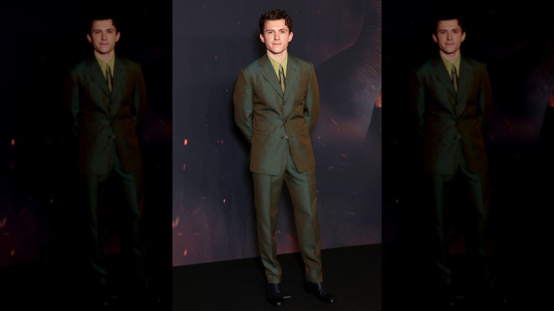 Tom Holland posing with his hands behind his back