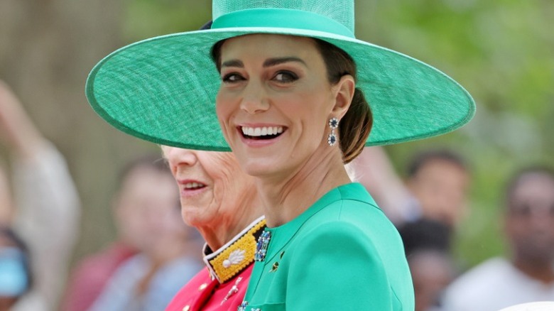 Kate Middleton smiles in a green hat and dress