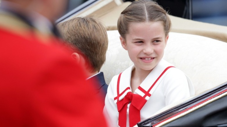 Princess Charlotte smiles in a red and white dress