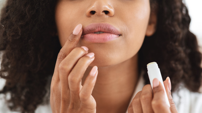 Woman applying lip balm