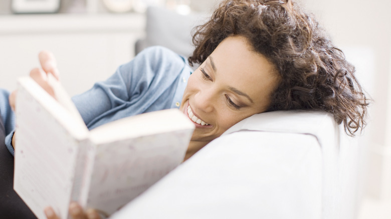 Woman reading a book in blue sweater