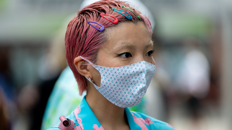 Woman with pink hair wearing mask