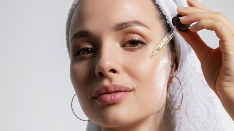 Woman putting serum on her face