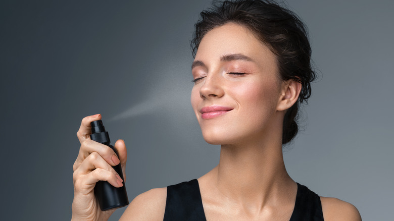 Woman using a setting spray to finish makeup