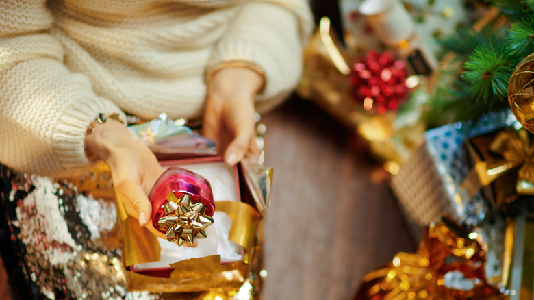 A woman holding a face cream gift