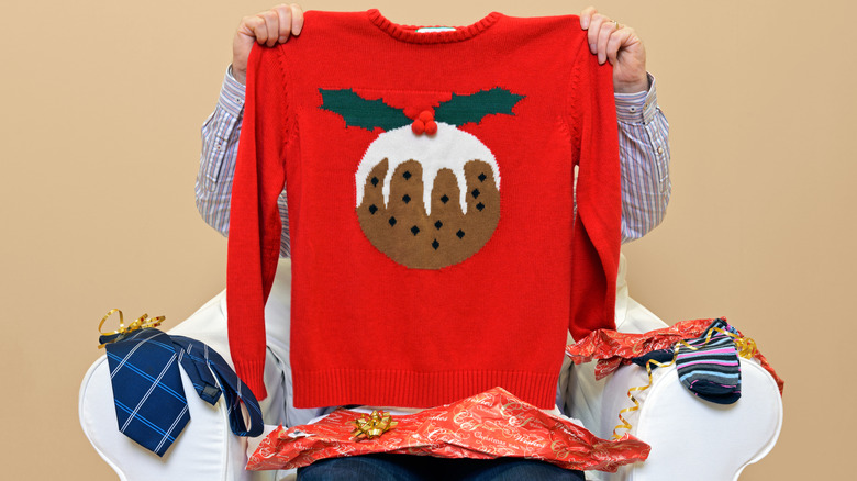 Man holding up sweater gift 