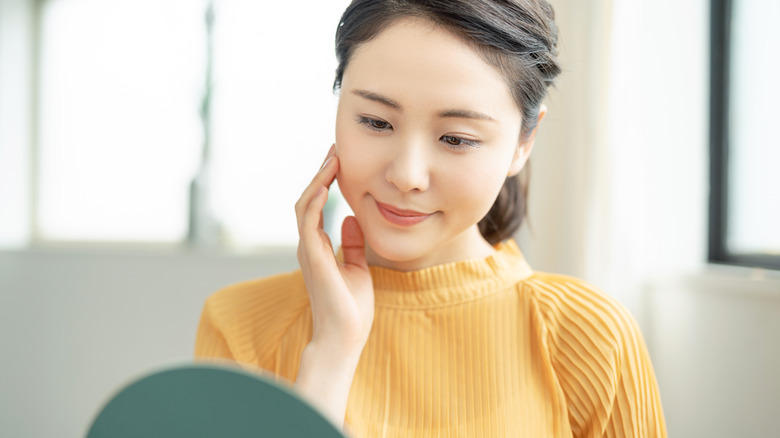 A woman inspecting her face