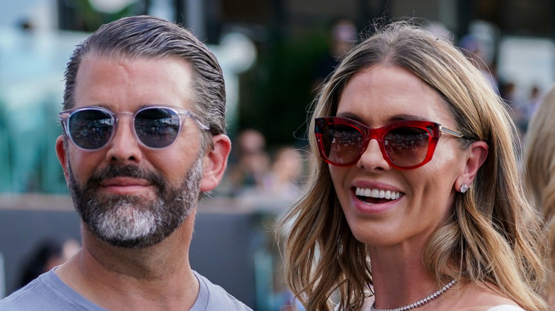 Bettina Anderson smiling in sunglasses next to Donald Trump Jr.