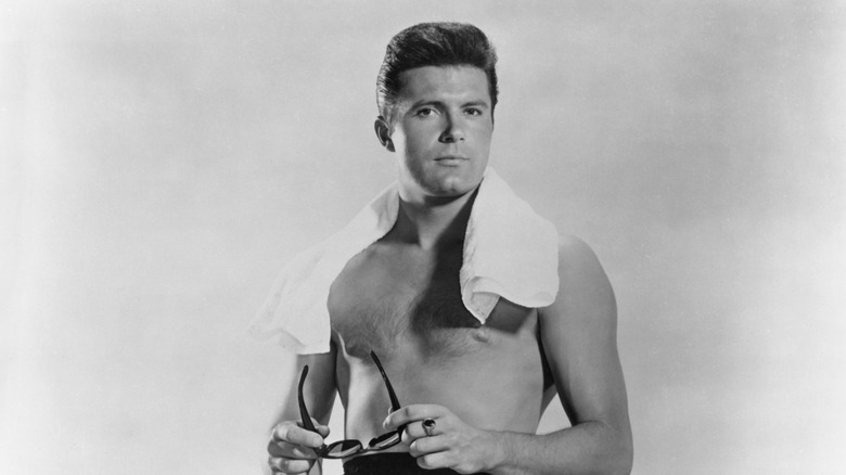 A black-and-white photograph of Max Baer Jr. shirtless
