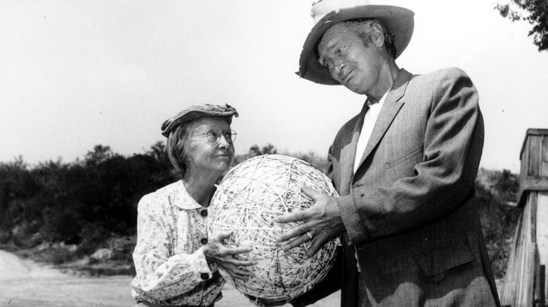 Irene Ryan and Buddy Ebsen holding a giant yarn ball and looking at each other skeptically