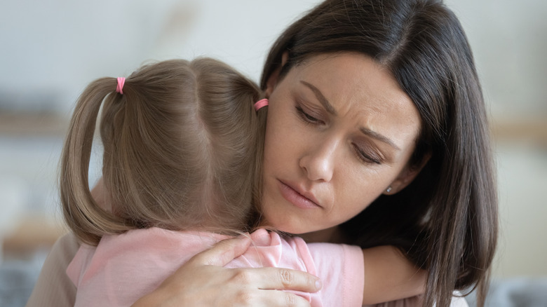 Worried mother hugging child