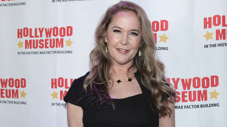 Erin Murphy smiling in a black dress while attending a red carpet event