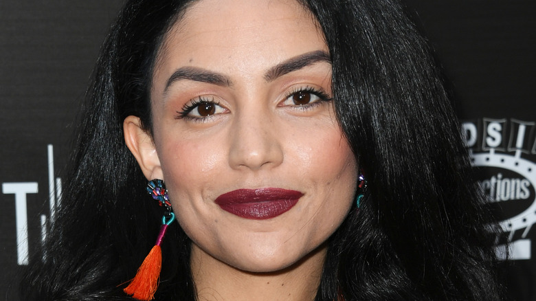 Bianca A. Santos smiling with dangling earrings on red carpet