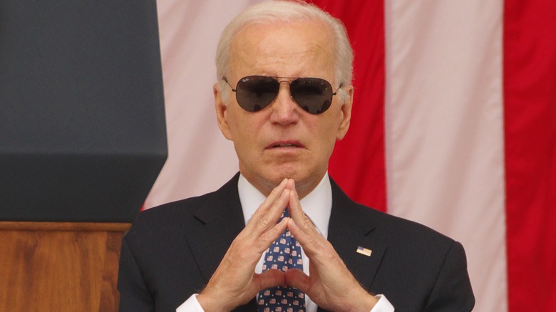 Joe Biden touching fingers together, wearing sunglasses