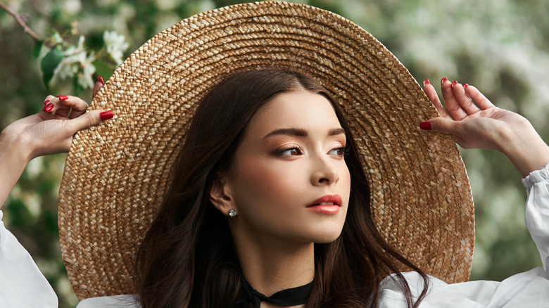 woman wearing big hat in forrest