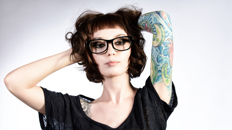 woman with glasses and arm sleeve tattoo