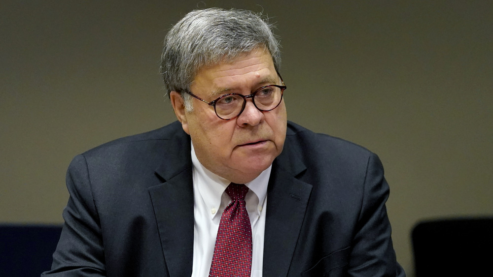 Attorney General Bill Barr sits at a table. 