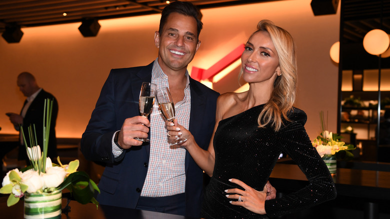 Bill & Giuliana Rancic making a toast while smiling