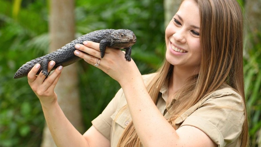 Bindi Irwin smiles holding lizard