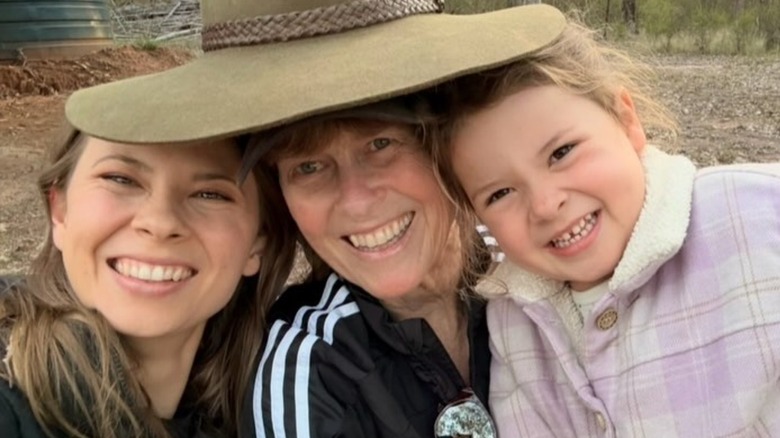 Bindi Irwin, Terri Irwin, and Grace smile together under one big hat