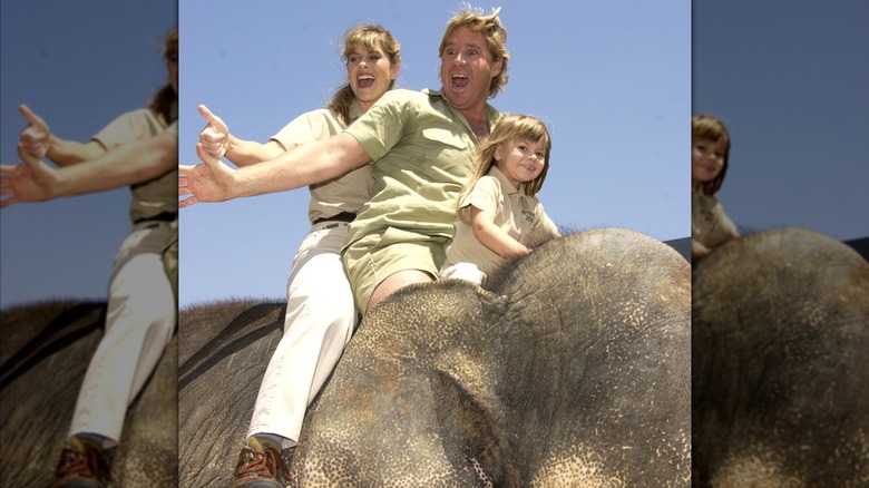 Terri, Steve, and Bindi Irwin riding an elephant.