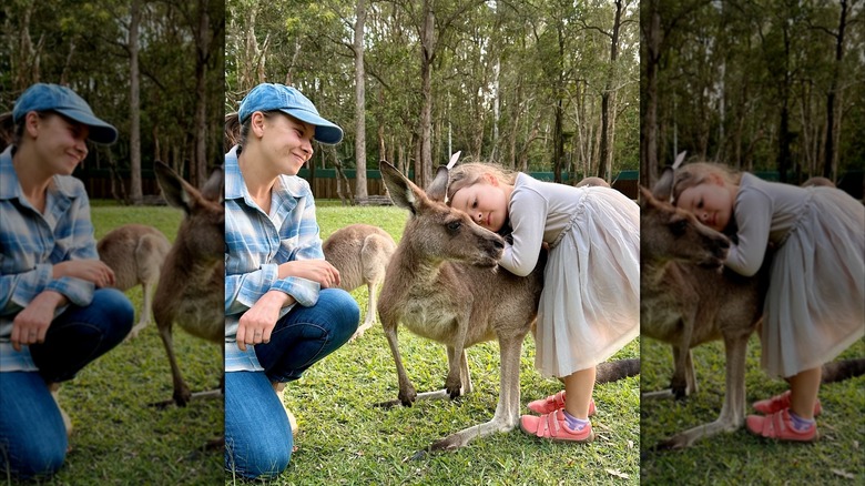 Bindi smiles at Grace as she hugs a kangaroo