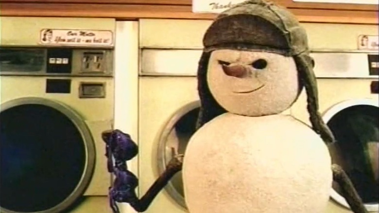 A snowman holding a bra in a laundromat.
