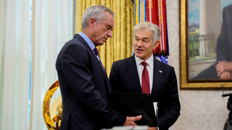 Dr. Oz talking to RFK Jr. while he looks down