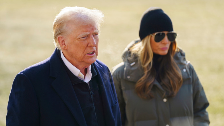 Donald Trump speaking to reporters outside the White House with Melania Trump next to him