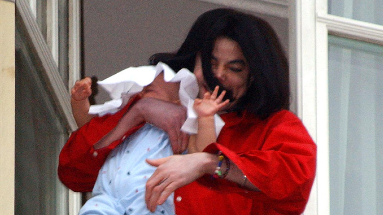 Michael Jackson dangling Blanket Jackson off a balcony