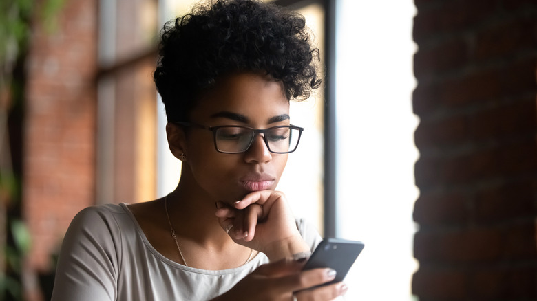 Woman scrolling through social media on phone