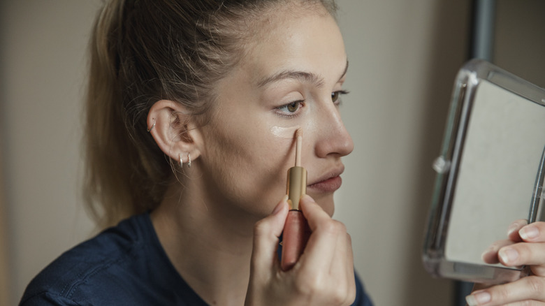 woman applying concealer