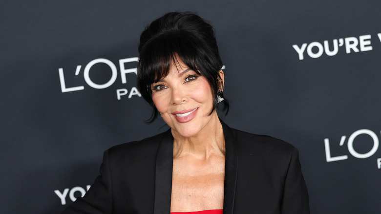 Kris Jenner closup red lip, black jacket over a red dress