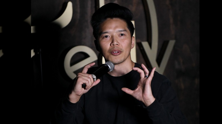 Alex Duong performs at a comedy event in 2021