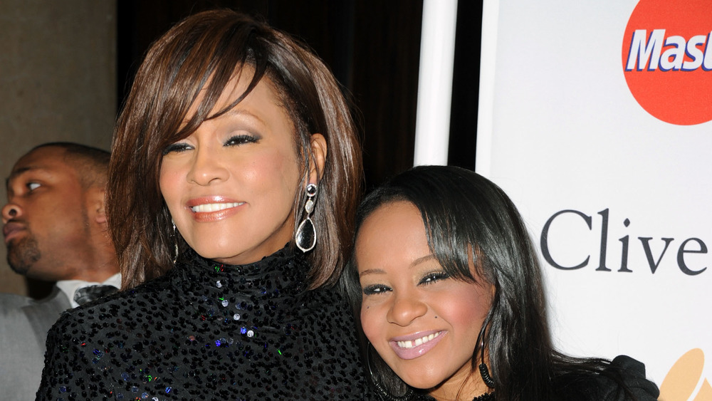 Bobbi Kristina Brown and her mother Whitney Houston smile at an event together